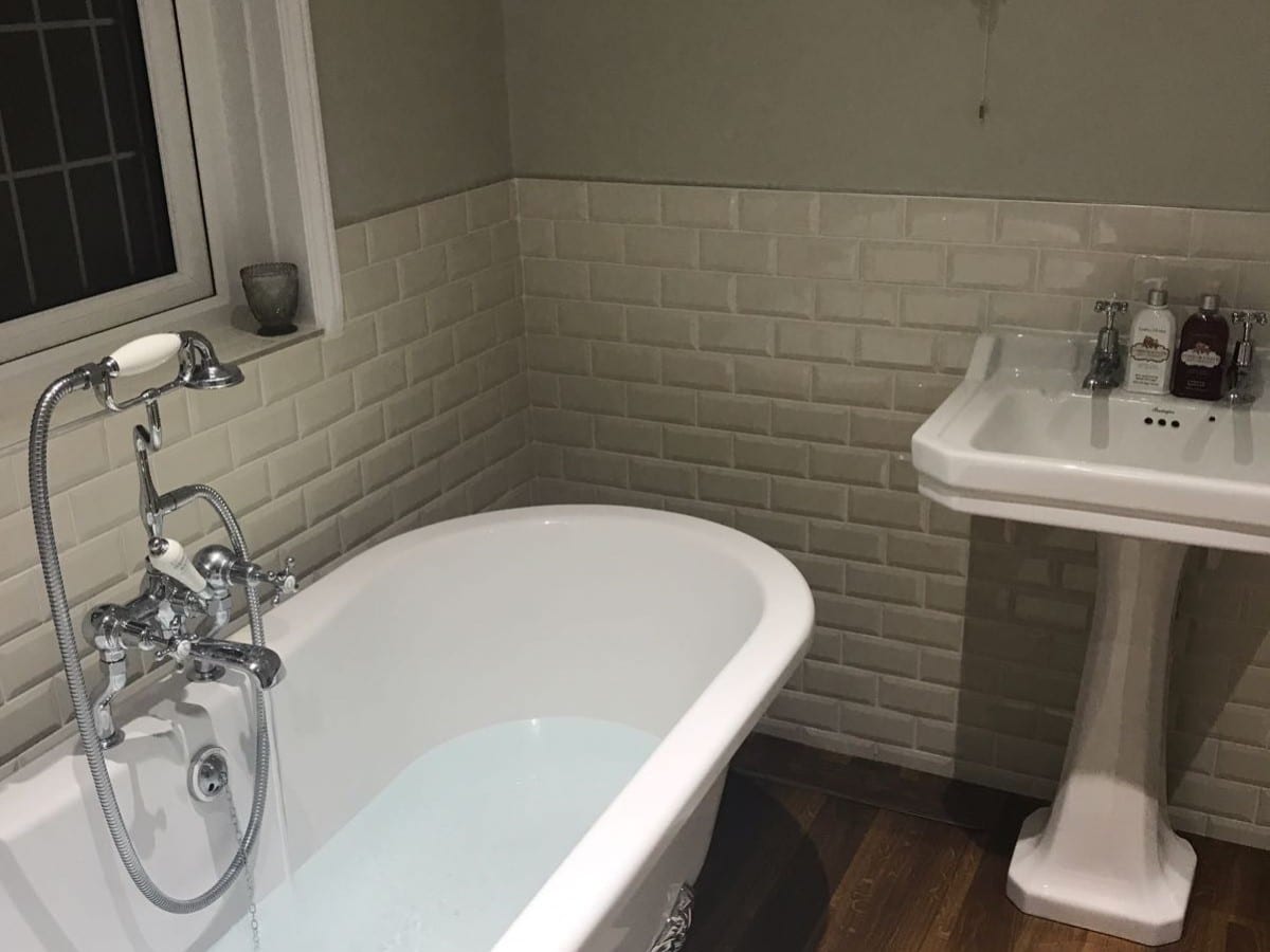 traditional feeling bathroom with a freestanding bath and white bevel tiles