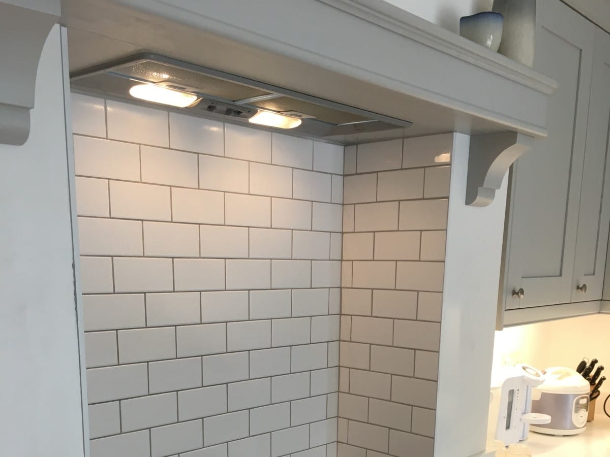 enclosed cooker hood splashback using white metro tiles