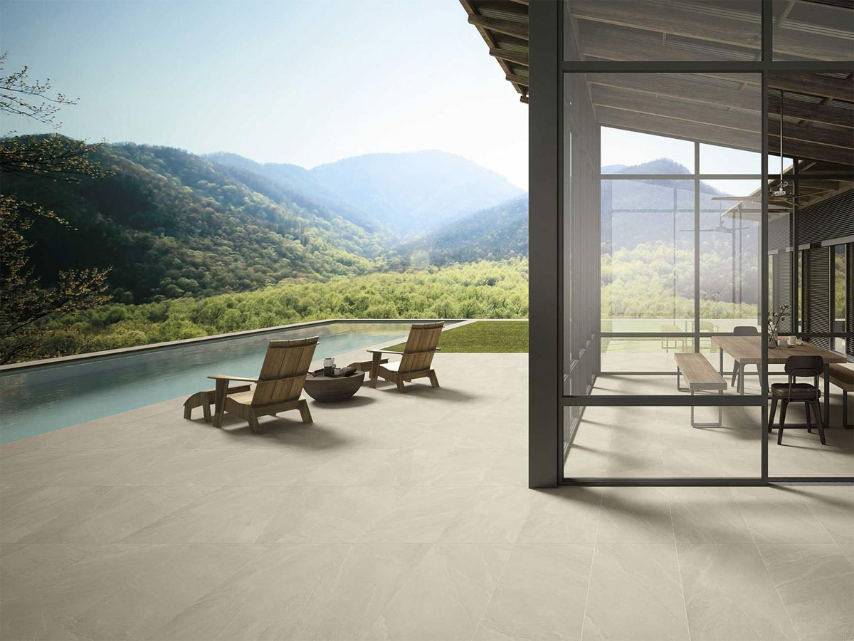 mountainside pool area with lounge chairs and conservatory