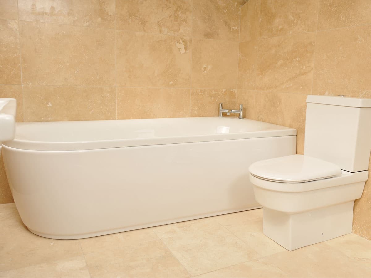 a travertine tiled bathroom suite